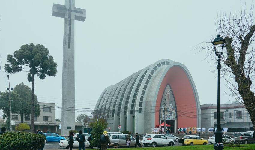 Grupo de personas con cámaras fotográficas, de fondo aparece la Catedral de Chillán.