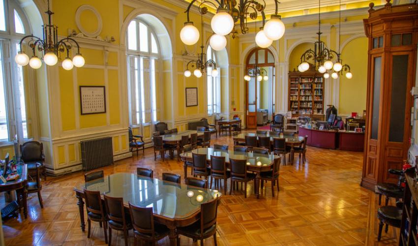 Sala de lectura con tres mesas desocupadas para público.
