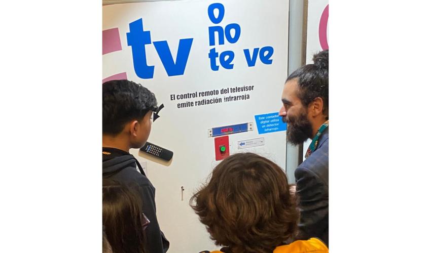 Visitantes aprendiendo con profesor guía sobre ondas en módulo interactivo del Museo de Ciencia y Tecnología