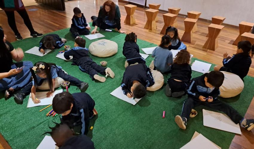 Niñas y niños observando dibujando en el museo