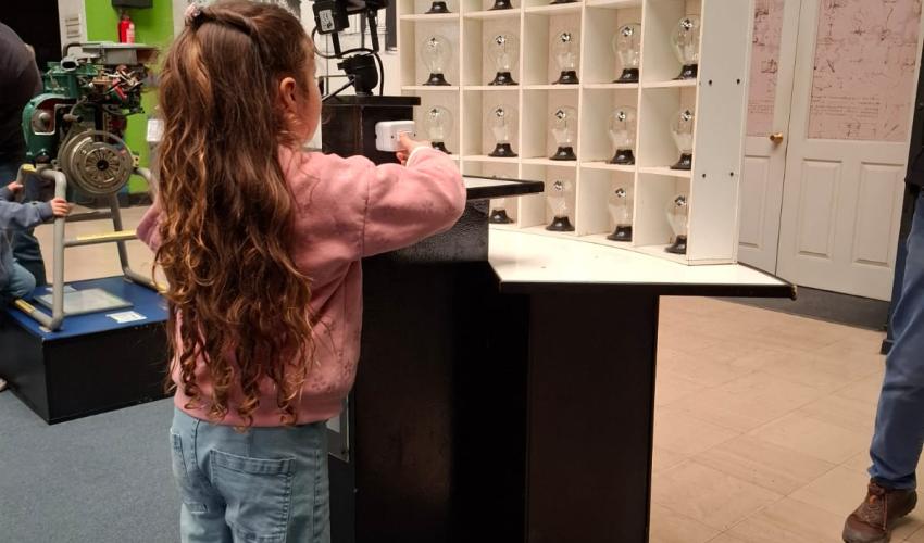 Niña aprendiendo sobre efectos de la luz en módulo interactivo del Museo de Ciencia y Tecnología